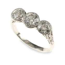An antique 1920s-era platinum hand-fabricated filigree 3-diamond ring